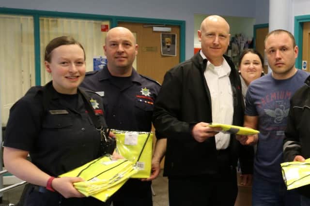 Rosmini Centre staff receiving the jackets from Wisbech firefighters