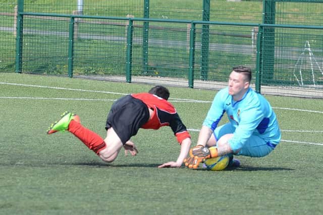 Ramsey manager/goalkeeper Lea Jordan slides out to thwart an attack from Netherton United A. Photo: David Lowndes.