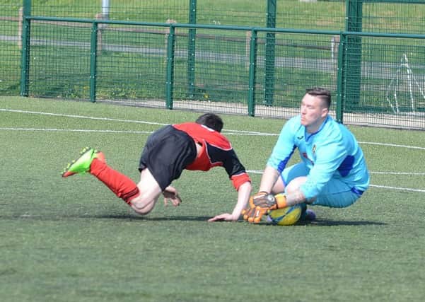 Ramsey manager/goalkeeper Lea Jordan slides out to thwart an attack from Netherton United A. Photo: David Lowndes.