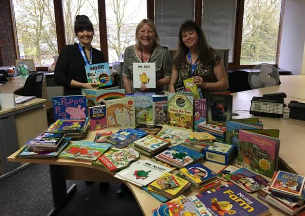 Staff at BGL with some of the books donated to schools.