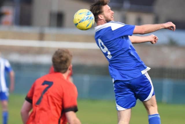 Gary Gibbs (blue) in action for Peterborough Sports Reserves against Pinchbeck. Photo: David Lowndes.