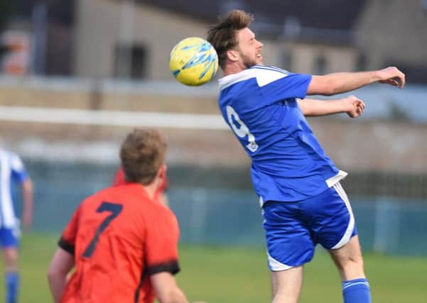 Gary Gibbs (blue) in action for Peterborough Sports Reserves against Pinchbeck. Photo: David Lowndes.