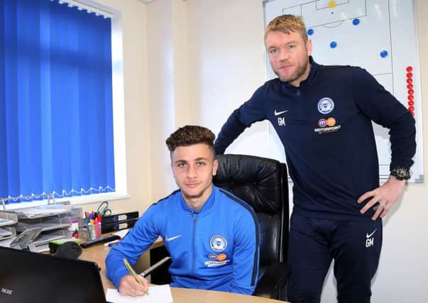 Andrea Borg puts pen to paper watched by Grant McCann. Picture: Joe Dent