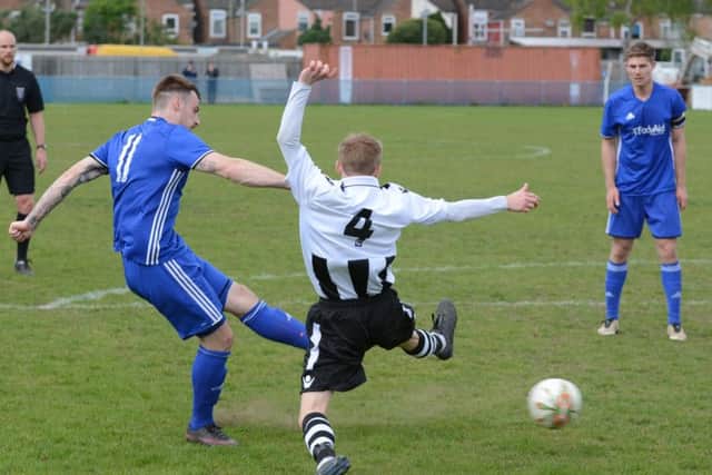 Josh Moreman shoots at goal for Peterborough Sports against Peterborough Northern Star as hat-trick hero Mark Jones looks on. Photo: David Lowndes.