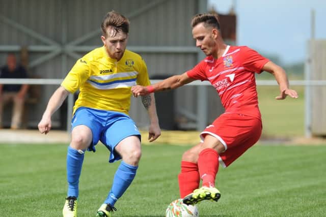 Billy Smith (red) claimed a hat-trick for Wisbech against Holbeach.