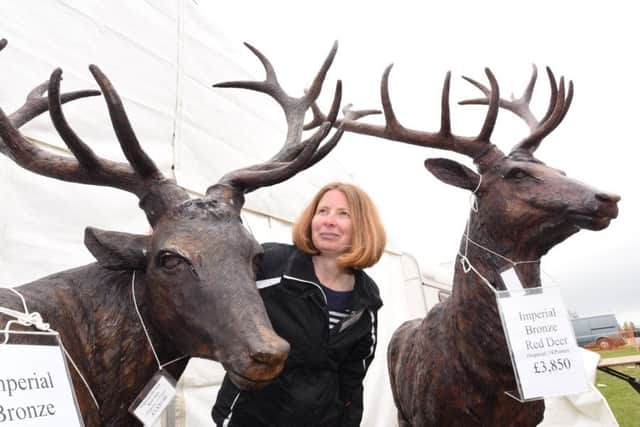 the East of England showground antiques fair.   Dealer Annette McCullagh with a pair of stags for sale EMN-170414-194603009