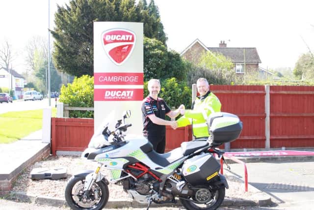 PC Simon Burgin receiving the bike from Ducati Customer Specialist Graeme Spence at Ducati Cambridge.