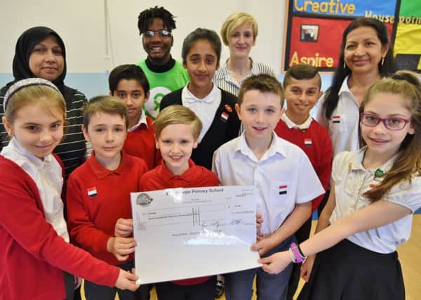 Longthorpe Primary School Council   with  staff Nazira Gavani,  Jyoti Edirisooriya and Sherry Green with Khulani Nyathi from Oxfam receiving a cheque from the pupils who raised ?731 from a cake sale. EMN-170704-092430009