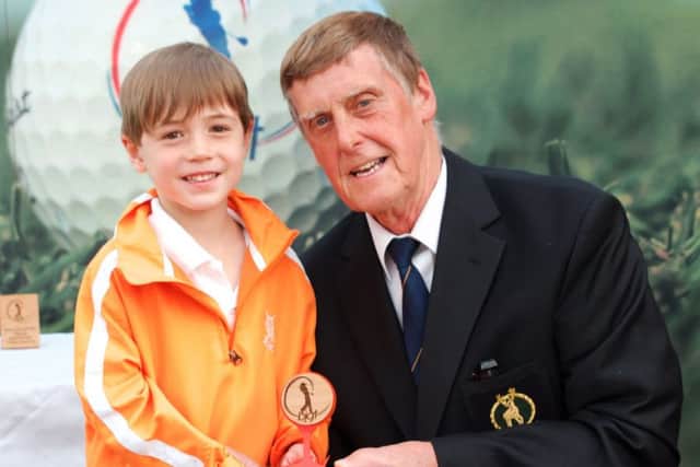 Bobby Moore receives his trophy after winning the British Junior Golf Tour event at Bourn Golf Club from the clubs captain John Fryer.