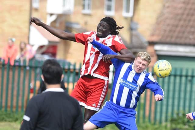 Ali Nyang (red) wins this aerial duel for Peterborough Sports Reserves against Moulton Harrox. Photo: David Lowndes.