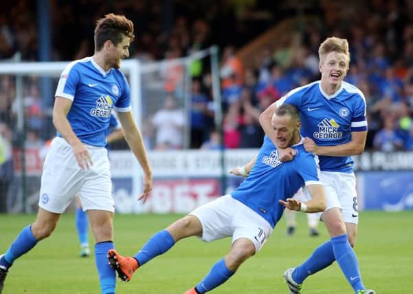 Posh star Marcus Maddison celebrates his goal against Millwall with team-mates Jack Baldwin (left) and Chris Forrester.