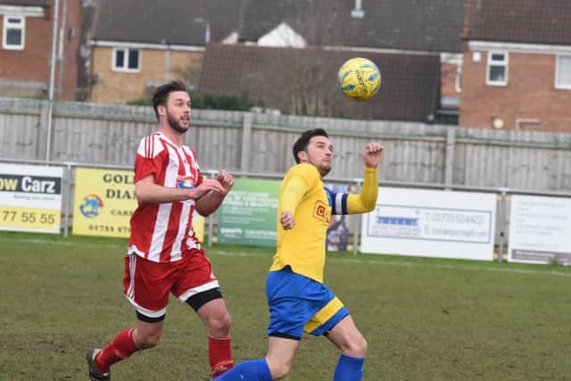 Gary Gibbs (stripes) scored for Peterborough Sports Reserves at Holbeach United.
