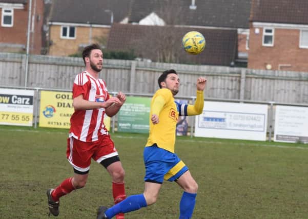 Gary Gibbs (stripes) scored for Peterborough Sports Reserves at Holbeach United.