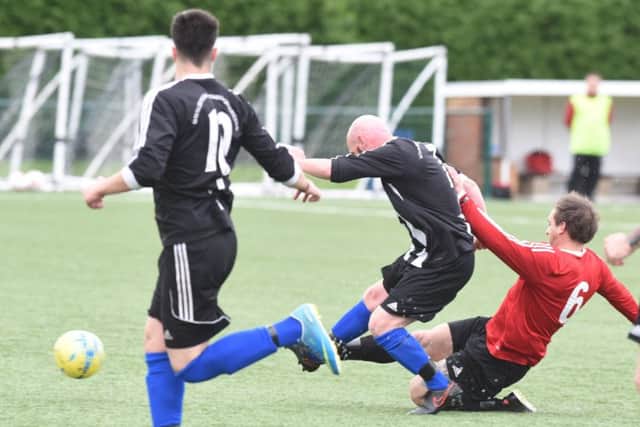 A strong challenge from a Tydd St Mary player (red) during a 4-1 Peterborough League Division Two play-off final win over Langtoft United Reserves. Photo: David Lowndes.