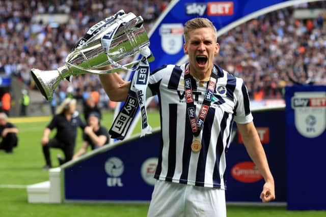 Millwall's Steve Morison celebrates with the League One play-off trophy.