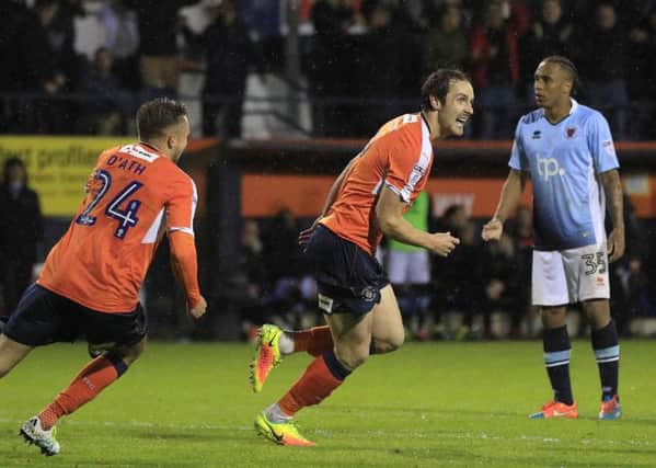 Shameless Luton striker Danny Hylton celebrates after tucking away a penalty he earned with a horrible dive.