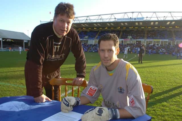 Mark Tyler signs a Posh contract watched by manager Tommy Taylor.
