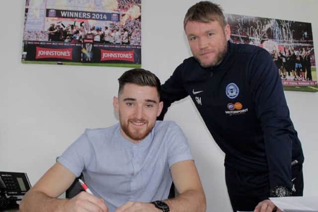 Jack Baldwin signs a new deal watched by Grant McCann.