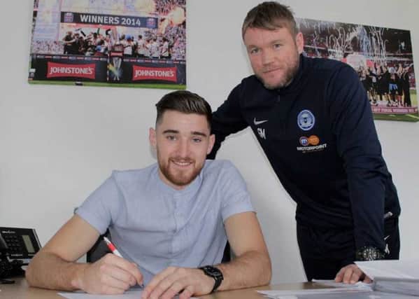 Jack Baldwin signs a new deal watched by Grant McCann.
