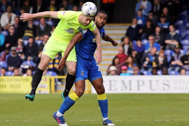Andrew Hughes of Peterborough United beats Tyrone Barnett of AFC Wimbledon to the ball. Picture: Joe Dent
