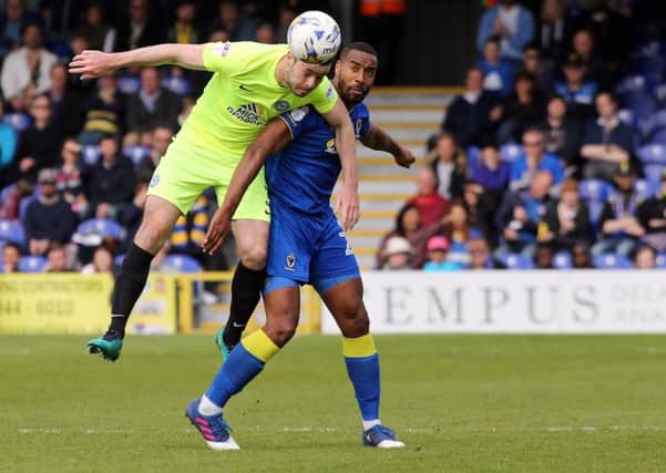 Andrew Hughes of Peterborough United beats Tyrone Barnett of AFC Wimbledon to the ball. Picture: Joe Dent