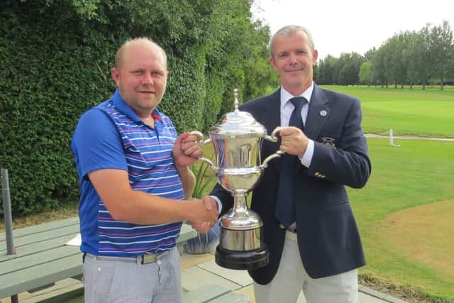 March club champion Gary Neugebauer receives his trophy from club captain Ivan Roberts.