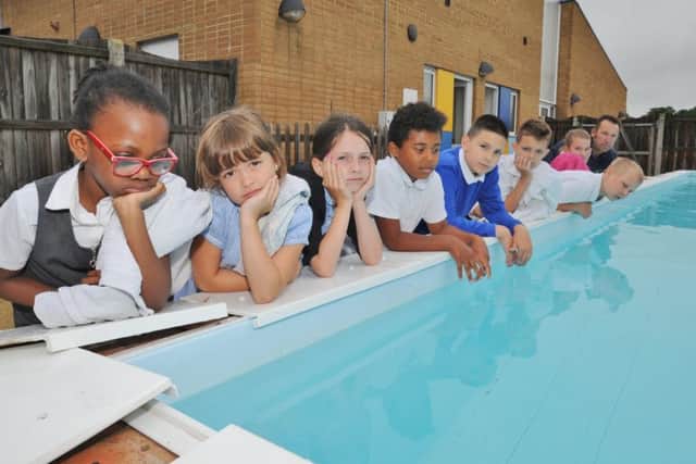 Rose Affleck (front left)and pupils from Paston Ridings primary school with site officer Ian Jinks (back right) looking at their damaged pool. EMN-170628-163847009