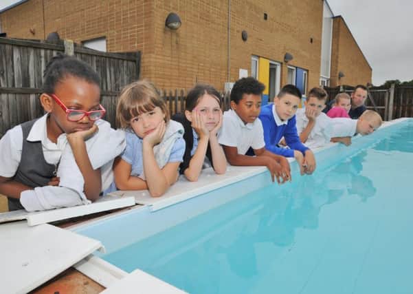 Rose Affleck (front left)and pupils from Paston Ridings primary school with  site officer Ian Jinks (back right) looking at their damaged pool. EMN-170628-163847009