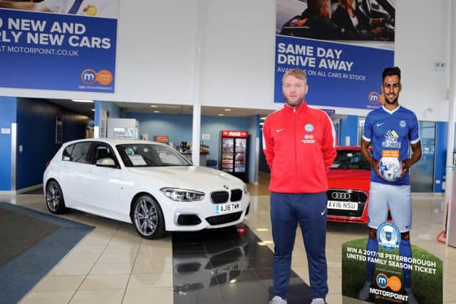 Posh manager Grant McCann with a cut-out of central defender Ryan Tafazolli at the Motorpoint showroom.