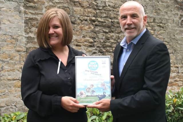 Ramblewood Inn supervisor Charlotte Marriott receives the Dog Friendly Pub certificate on behalf of Just Dogs Live Ian Strange, head of internal events at the East of England Arena and Events Centre.
