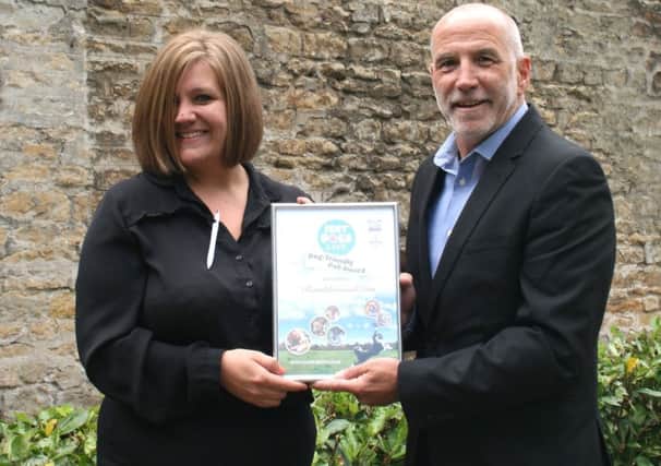Ramblewood Inn supervisor Charlotte Marriott receives the Dog Friendly Pub certificate on behalf of Just Dogs Live Ian Strange, head of internal events at the East of England Arena and Events Centre.