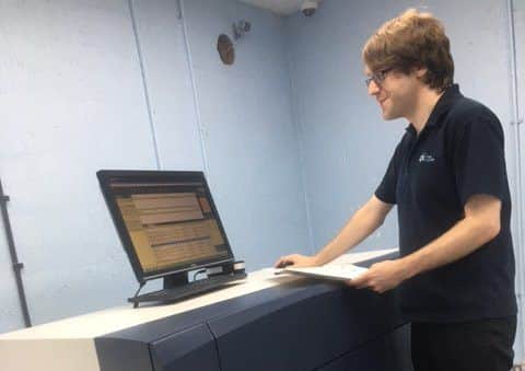 Luke Warren operates the new digital printing press.