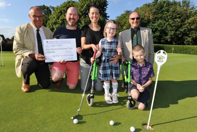 Milton Tree Iron Society captain Mike Walters (left) and Patrick Garner (right) present £500 from the society to Halle Heriot (4) and mum Fran, dad Tim and brother Theo (7). EMN-170713-211917009