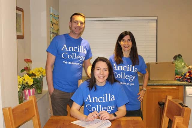 Eleanor Boothman signs on at Ancilla College in front of parents Robert and Lesley Boothman.
