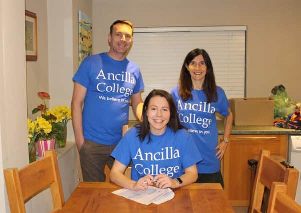 Eleanor Boothman signs on at Ancilla College in front of parents Robert and Lesley Boothman.