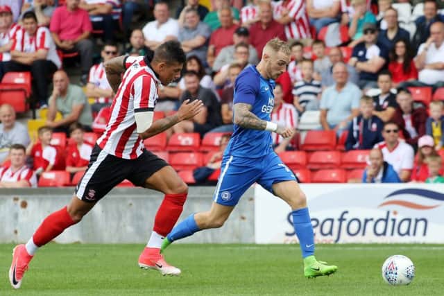 Marcus Maddison charges past Matthew Briggs of Lincoln. Photo: Joe Dent/theposh.com.