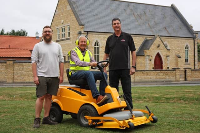 Peter Thompson the Chair of the DRA (on the mower), Cllr Craig Rudd of Bretton Parish Council (in shorts) and Tom Calton, Managing director of the Peterborough Mower and Groundcare Centre (in black).