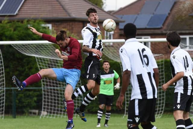 Peterborough Northern Star defender Matt Cox wins this aerial duel in the FA Cup defeat by Deeping Rangers. Photo: Chantelle McDonald.  @cmcdphotos.