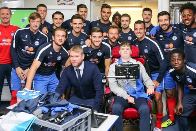 The Peterborough United squad pose for a picture with Ryley in the changing room before the game
