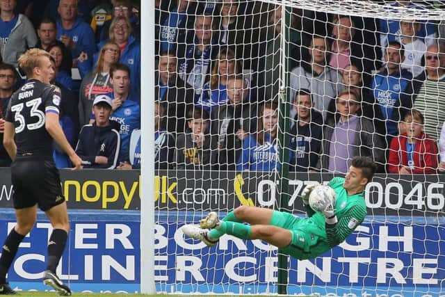 Posh goalkeeper Jonathan Bond makes a diving save against Wigan. Photo: Joe Dent/theposh.com.
