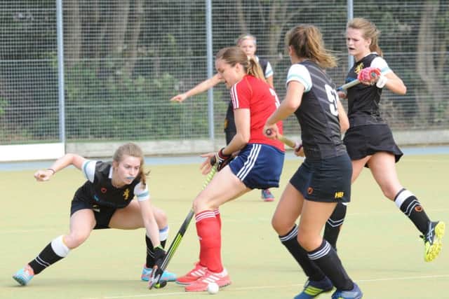 Verity Allen (red) fights for possession during City of Peterborough Ladies' big win over Cambridge University. Photo: David Lowndes.