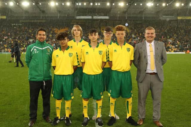 Students from Thomas Deacon Academy pictured on the Carrow Road pitch with Dominic Knighton (RDP manager) and Stevie Bramble (Head of Curriculum) at half-time of the first team fixture against Birmingham City.