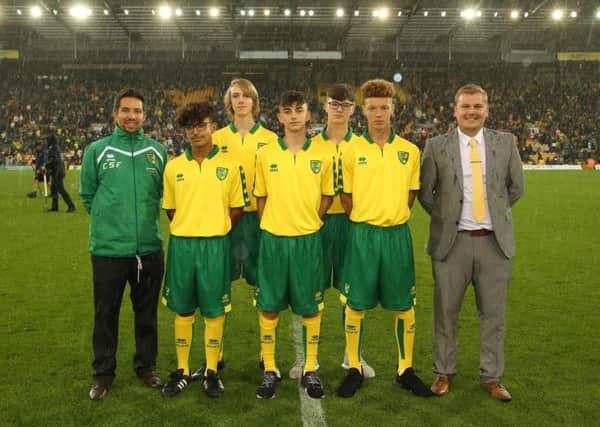Students from Thomas Deacon Academy pictured on the Carrow Road pitch with Dominic Knighton (RDP manager) and Stevie Bramble (Head of Curriculum) at half-time of the first team fixture against Birmingham City.