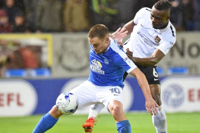Former Posh defender Gaby Zakuani (right) will be in action at the ABAX Stadium on October 14.