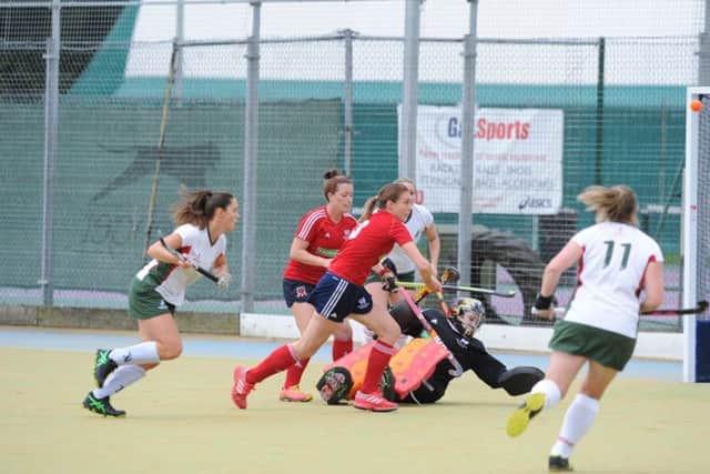 City of Peterborough goalkeeper Holly Riches and her defence (red) clear the ball against Norwich Dragons. Photo: David Lowndes.