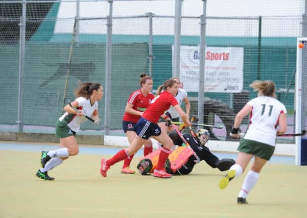 City of Peterborough goalkeeper Holly Riches and her defence (red) clear the ball against Norwich Dragons. Photo: David Lowndes.