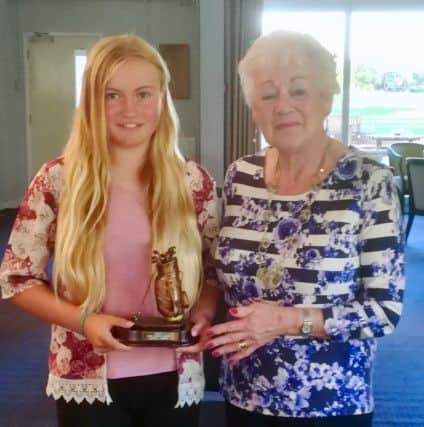 Christine Patrick presents the trophy she donated to junior captain Emily Horsted.