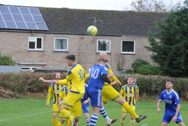 An aerial duel during ICA Sports 3-1 over Moulton Harrox (yellow) in the Peterborough Premier Division. Photo: David Lowndes.