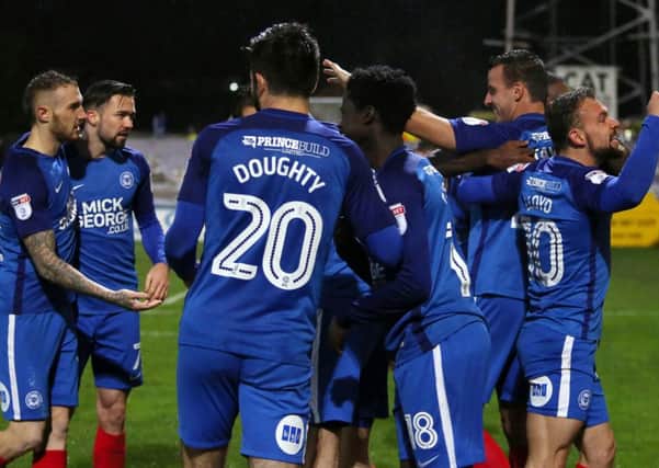 Steven Taylor is mobbed by team-mates after scoring for Posh at Cambridge. Photo: Joe Dent/theposh.com.
