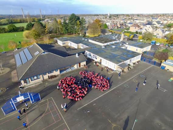 Children at  Park Lane Primary School forming the poppy